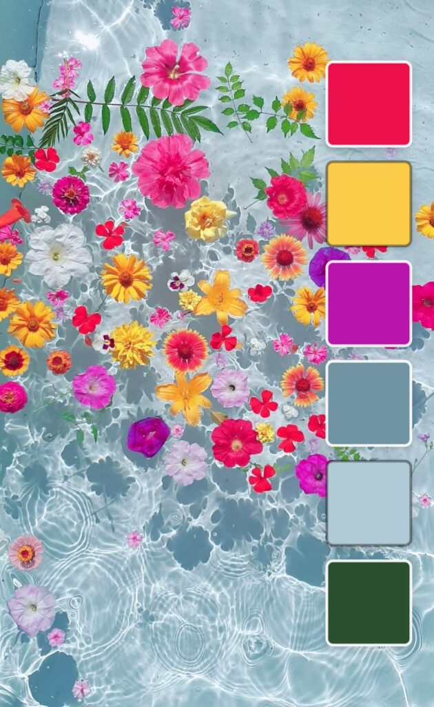 A colorful arrangement of flowers floating on water with shades of pink, yellow, blue, and green.